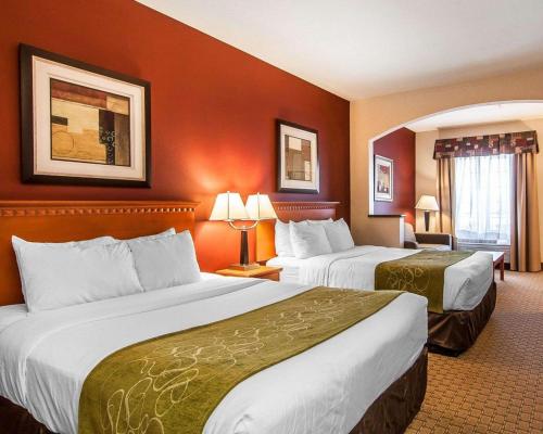two beds in a hotel room with red walls at Comfort Suites Redmond Airport in Redmond