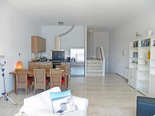 a living room with a table and a kitchen at Vakantieappartement de Kabbelaar in Ouddorp