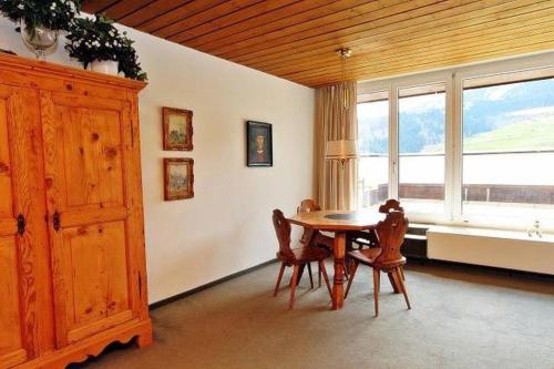 d'une salle à manger avec une table, des chaises et une fenêtre. dans l'établissement Penthouse Tgesa Tgampi T33, à Savognin