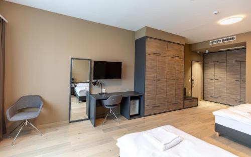 um quarto com uma cama, uma secretária e uma televisão em A22 Hotel Gyál em Gyál