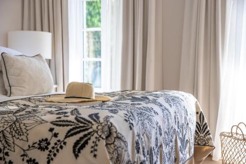 a hat is sitting on a bed in a bedroom at Villa Clarisse & Spa by Olivier Claire in Saint-Martin-de-Ré