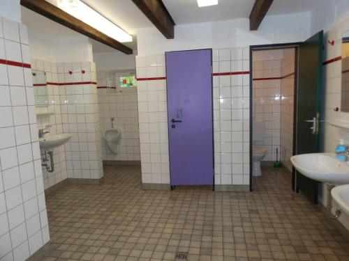 a bathroom with two sinks and a purple door at Das Haus mit der roten Telefonzelle in Apen