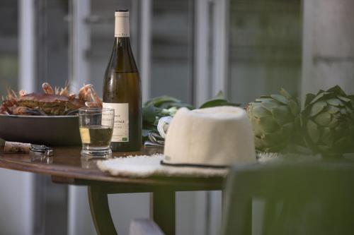 a bottle of wine and a glass on a table at Villa Clarisse & Spa by Olivier Claire in Saint-Martin-de-Ré