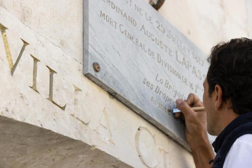 a man is looking at a sign on a wall at Villa Clarisse & Spa by Olivier Claire in Saint-Martin-de-Ré