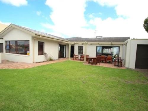 a house with a lawn in front of it at 12 on Beach Guest House in Saldanha