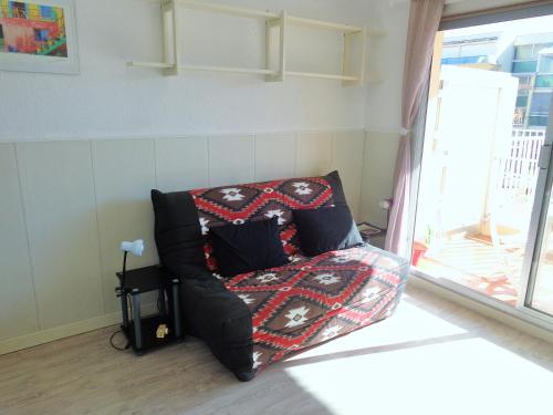 ein Sofa mit einer Decke darauf im Wohnzimmer in der Unterkunft STUDIO 2 PERS QUARTIER DES PLAGES DE LA CORNICHE in Sète