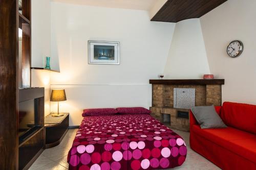 een woonkamer met een rode bank en een rood bed bij A Casa di Maria in Sirolo