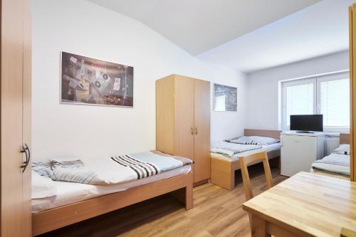 Zimmer mit 2 Etagenbetten und einem Tisch in der Unterkunft Apartmány Ubytování Alfa in Prag