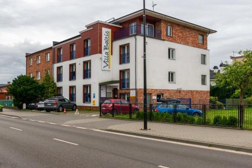 a building on a street with cars parked in front of it at Villa Baltic Chałupy - Apartament nr 1 in Chałupy