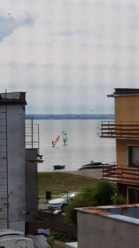 two people are flying kites on the water at Villa Baltic Chałupy - Apartament nr 1 in Chałupy