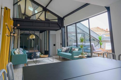- un salon décloisonné avec une table et des chaises dans l'établissement NOCNOC - Le Loft, terrasse comédie, à Montpellier