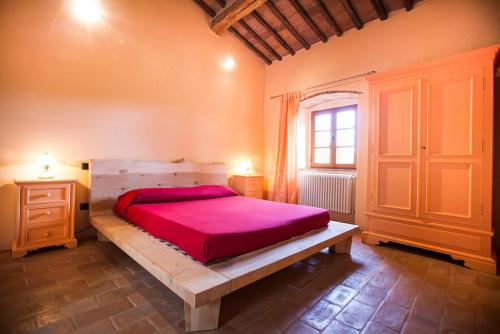 a bedroom with a large bed with a red blanket at Fattoria Le Fonti in Poggibonsi
