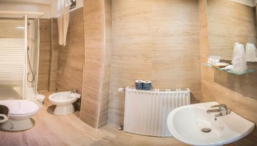 a bathroom with a white sink and a toilet at Galleria Frascati Rooms and Apartment in Frascati
