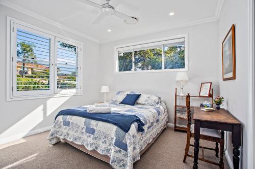 1 dormitorio con cama, mesa y ventanas en Jetty Splendour Guest Bedroom with Bathroom en-suite B'nB en Coffs Harbour