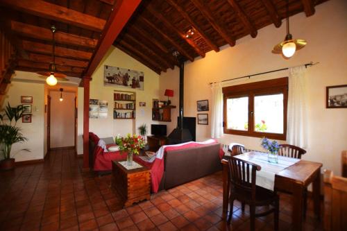 uma sala de estar com uma mesa e um sofá em Casa del Altozano em Barajas de Gredos