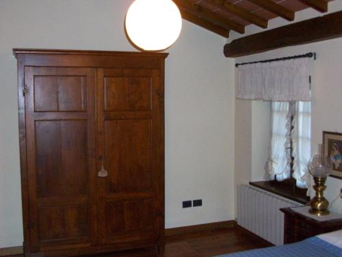 a bedroom with a wooden cabinet and a window at Casa Daniela in Pietrasanta