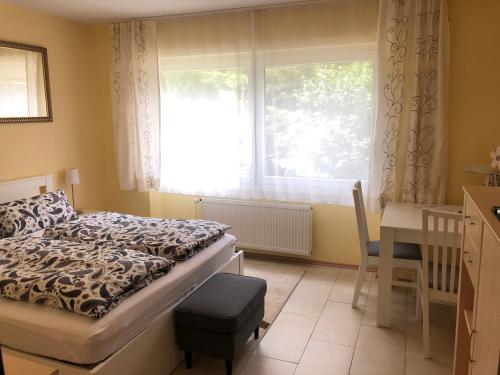 1 dormitorio con cama, escritorio y ventana en Ferienwohnung Appartement in Rheinbrohl, en Rheinbrohl