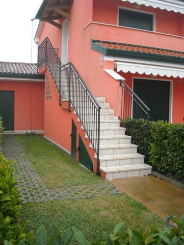 a red building with stairs on the side of it at RESORT VILLAGE AQUA MARINA FAMILY - Daily Rooms Tidying - CocktailsBar- Pet Friendly - with Hypermarket - Delivery Restaurant-Pizzeria - Room Breakfast with supplement - Ultra Fast Wi-Fi - Play Area for children - Olympic Swimming Pool - Parking in Caorle