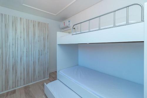 Habitación con estanterías blancas y armario. en Aluguel Apartamento 2 quartos vista mar Bombas/SC, en Bombinhas