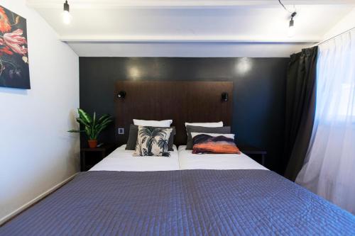 a bedroom with a large bed with two pillows at Quentin England Hotel in Amsterdam