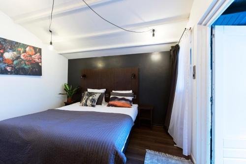 a bedroom with a bed and a painting on the wall at Quentin England Hotel in Amsterdam