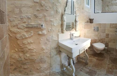 une salle de bain avec un lavabo et des toilettes dans l'établissement Chateau le Truch, à Montussan