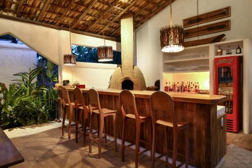 eine Bar mit einer Reihe von Stühlen in einem Restaurant in der Unterkunft Hotel Calá & Divino in Praia do Espelho