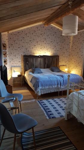 1 dormitorio con 1 cama, mesa y sillas en Nygården B&B Hälsingegård en Harmånger