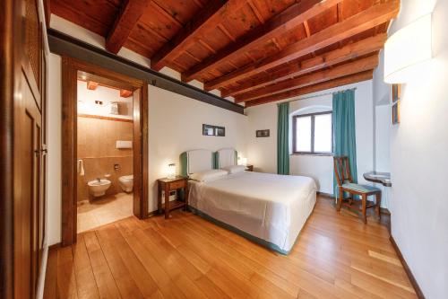 サンタンブロージョ・ディ・ヴァルポリチェッラにあるラ フォレステリア セレーゴ アリギエーリのベッドルーム1室(ベッド1台付)、バスルーム(トイレ付)