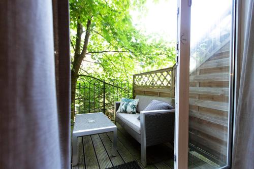 a porch with a couch and a table on a balcony at Quentin England Hotel in Amsterdam