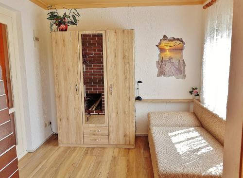 Habitación con armario de madera y ventana. en Bungalow Krzyzaniak, en Lohsa