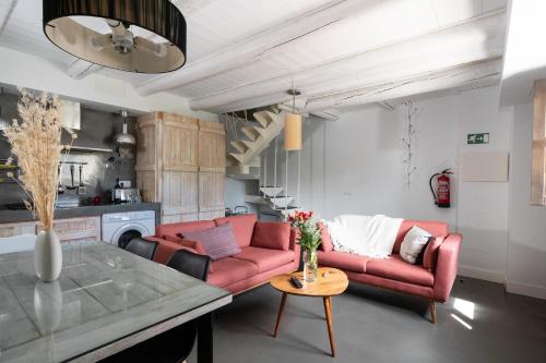 a living room with a red couch and a table at Casas Pirineos in Sabiñánigo