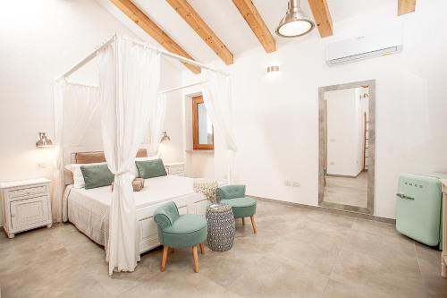 a bedroom with a bed and two chairs at La casa di Memmi Suites & Rooms in Santa Teresa Gallura
