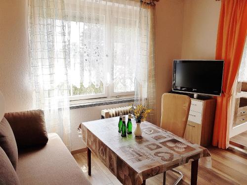 a living room with a table and a tv at Bungalow Krzyzaniak in Lohsa