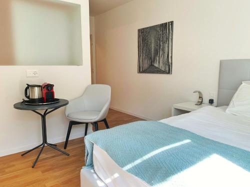 um quarto com uma cama, uma mesa e uma cadeira em Guesthouse Lochergut em Zurique