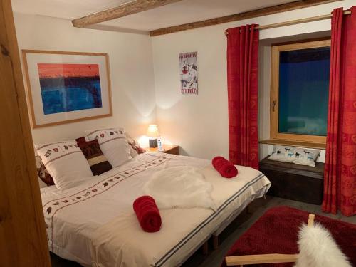 um quarto com uma cama com almofadas vermelhas em Chalet JJ em Sainte-Foy-Tarentaise