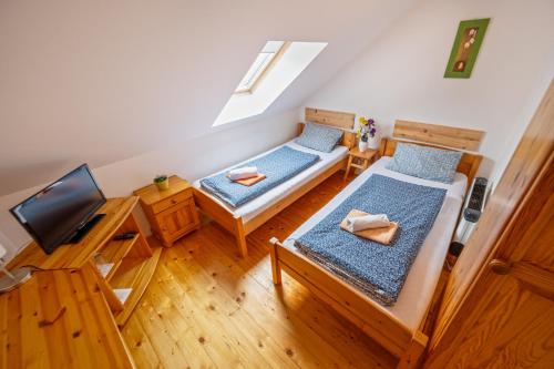 a small room with two beds and a television at Penzion U Kostela in Mikulčice