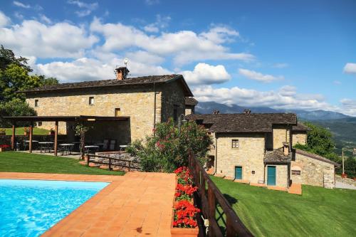 un gran edificio de piedra con una piscina frente a él en Costa D'Orsola, en Pontremoli