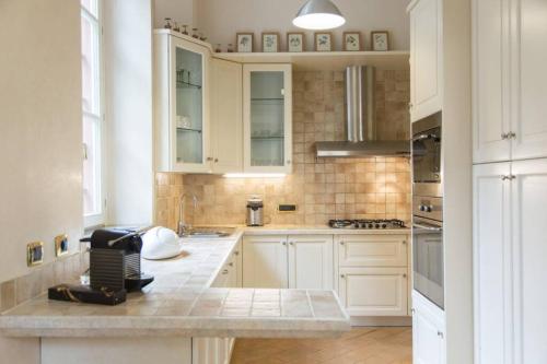 a kitchen with white cabinets and a counter top at Luxury Villa - Beach & Swimming Pool in Ghiffa