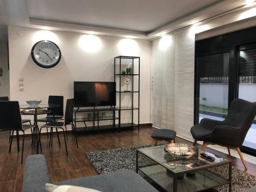 a living room with a tv and a clock on the wall at Ioannina Luxury Suites & Apartments in Ioannina