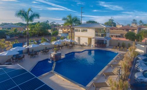 Pontal Praia Hotel في بورتو سيغورو: اطلالة علوية على مسبح مع كراسي ومظلات