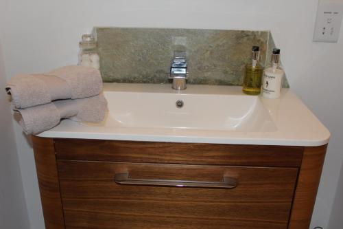 a bathroom sink with two bottles of alcohol and towels at Perky Pike in Keswick