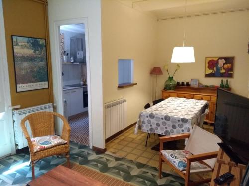 a living room with a table and chairs and a kitchen at Can Bonshoms in Ribes de Freser