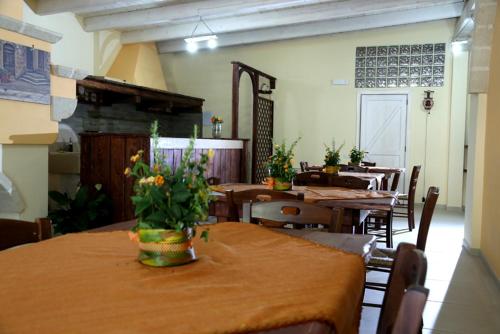 a dining room with tables and chairs with flowers on the table at Le Pentume in Arnesano