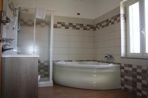 een badkamer met een groot bad en een douche bij B&B Paradiso in Falerna