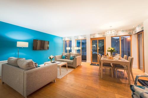 a living room with a table and a blue wall at Highland Apartments by Mansley in Inverness