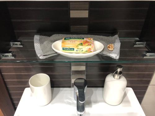 a bathroom with a sink with a cake and a plate at Ioannina Luxury Suites & Apartments in Ioannina