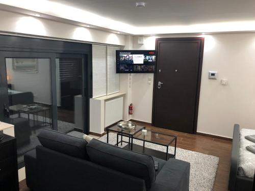 a living room with a couch and a table and a television at Ioannina Luxury Suites & Apartments in Ioannina