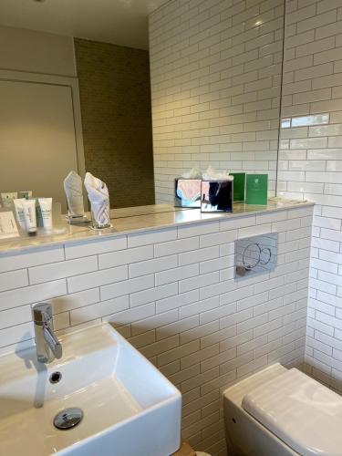 a bathroom with a sink and a mirror at Hatherley Manor Hotel & Spa in Gloucester