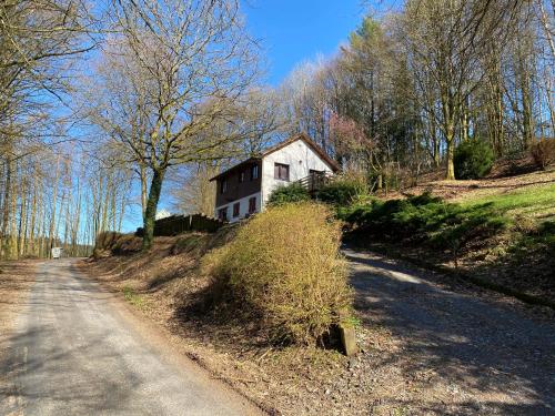 a house on a hill next to a road at Le Cap Vert in Rochehaut
